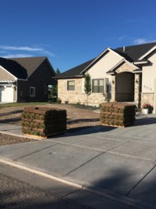 Two pallets of sod in front of a house ready for sod.