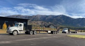 Two flat bed semi trucks loaded with sod.